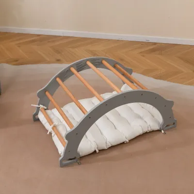 Dřevěný lezecký oblouk s měkkým polštářem na houpání, lezení a plazení. Lezecká věž šedá.